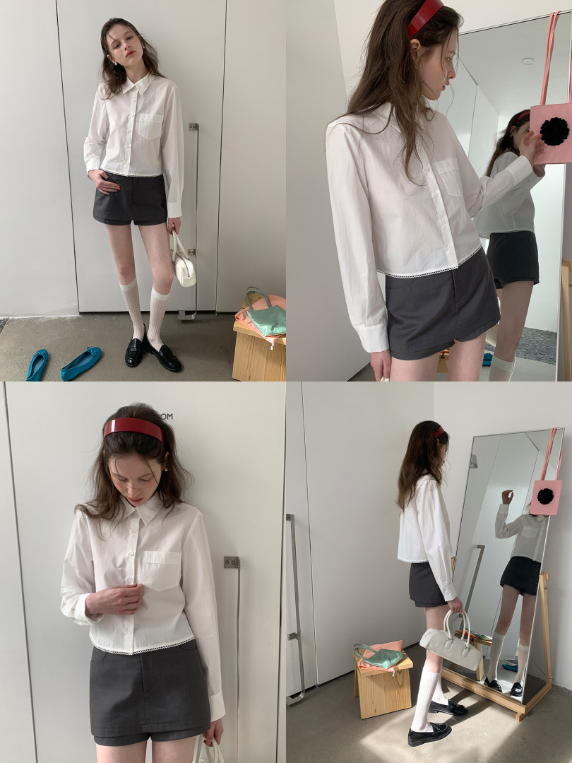 Model wearing a white button-up blouse with dark shorts