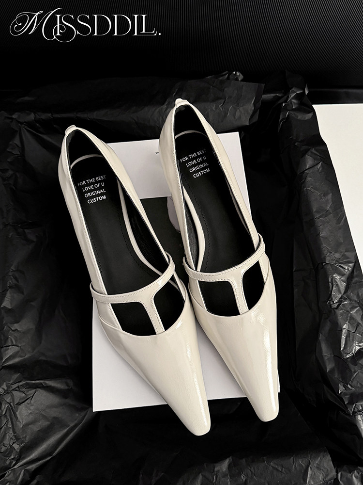 Pair of cream pointed-toe heeled shoes displayed on packaging