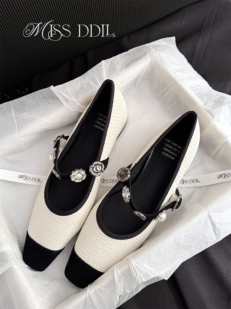 Pair of black and white embellished pointed-toe flats with ankle straps