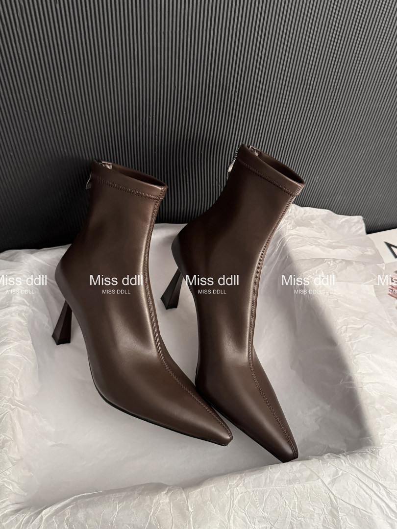 Brown pointed-toe high-heel ankle boots on white packaging