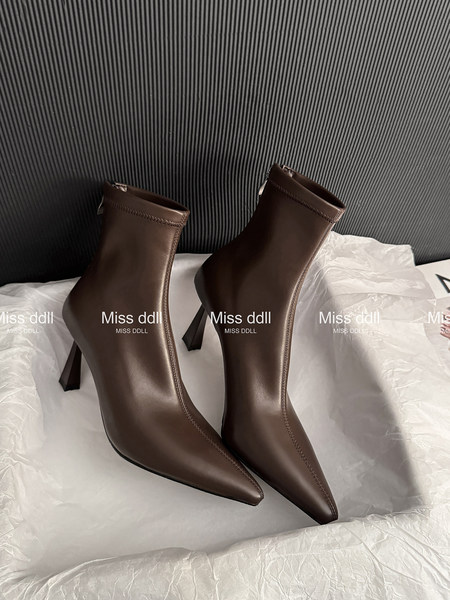 Brown pointed-toe high-heel ankle boots on white packaging
