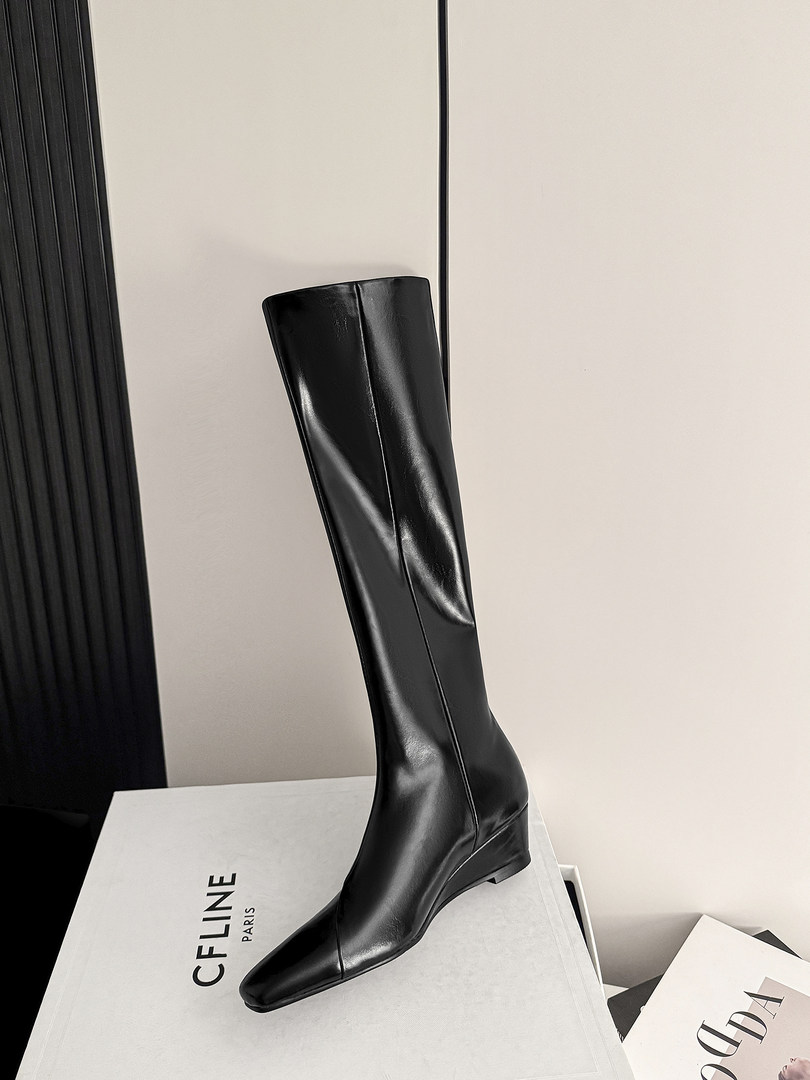 Black knee-high leather boot displayed on a box