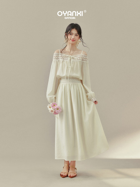 Model wearing a cream off-shoulder lace-trim dress with long sleeves