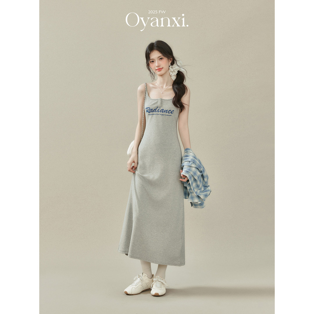 Model wearing a gray sleeveless midi dress with printed text