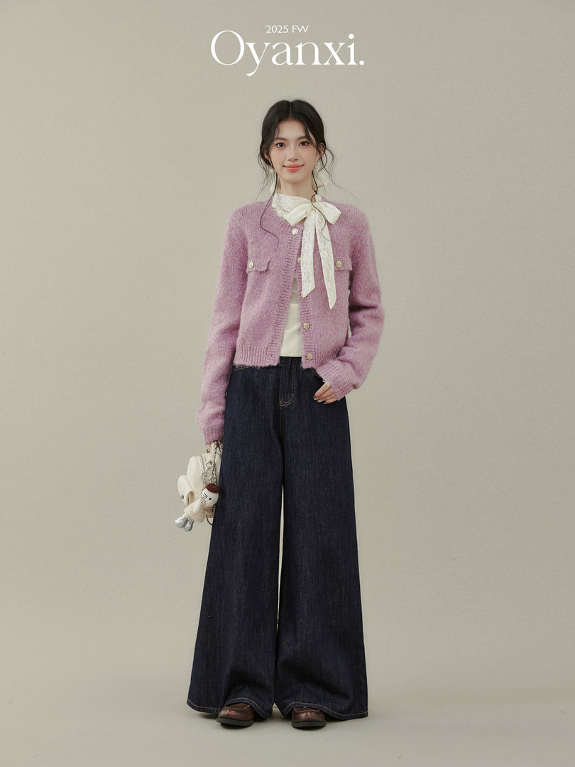 Model wearing a pink cardigan and wide-leg dark jeans