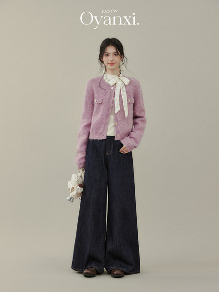 Model wearing a pink cardigan and wide-leg dark jeans