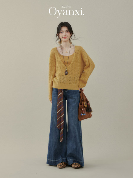 Model wearing a mustard knit sweater with wide-leg jeans and leopard flats