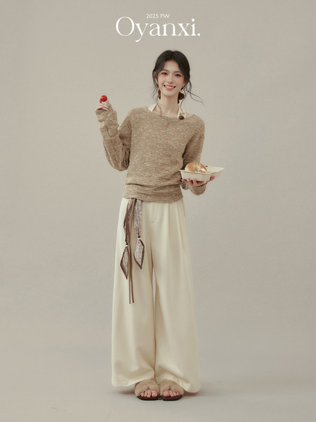 Model wearing a beige knit sweater and cream wide-leg pants