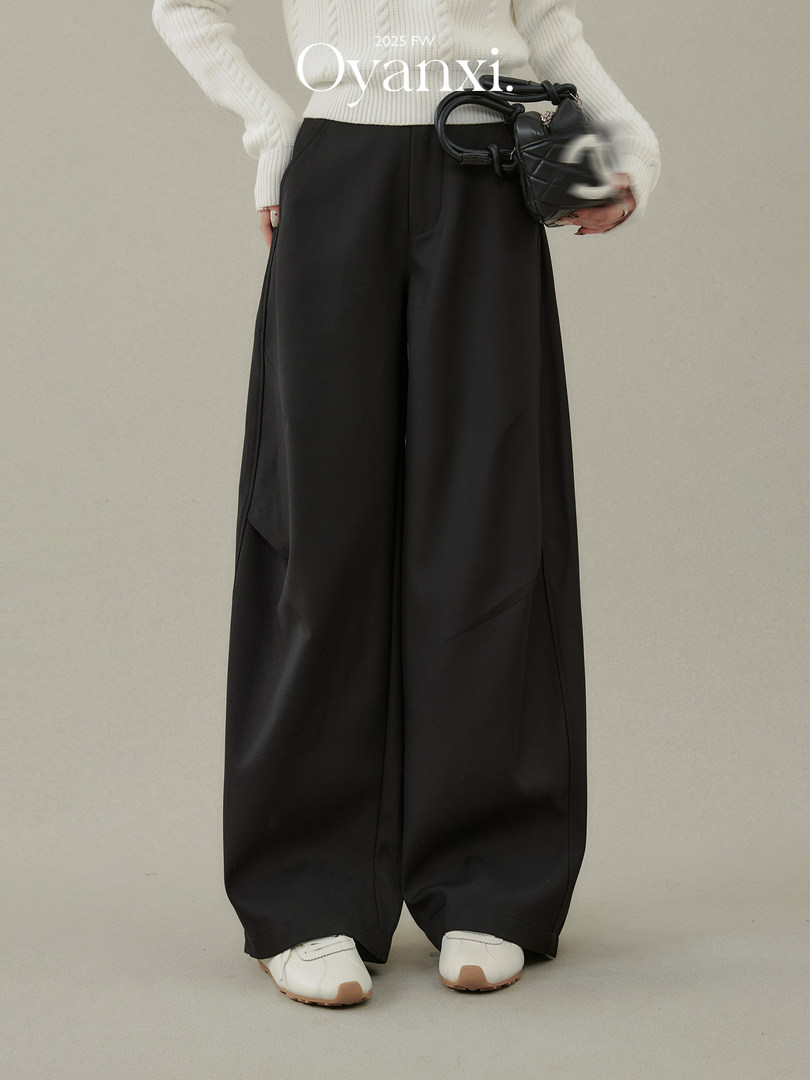 Black wide-leg pants worn with a white sweater and white shoes
