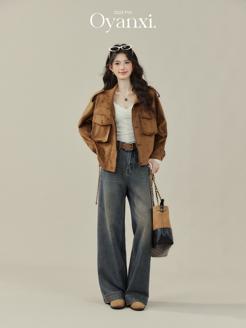 Fashion model wearing a brown jacket with wide-leg jeans and a handbag