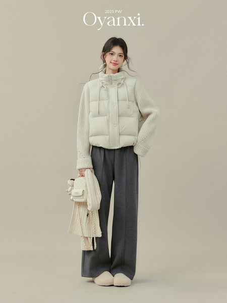 Model wearing a cream puffer vest with knit sweater and dark wide-leg pants