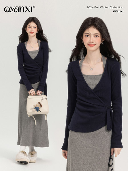Model wearing a navy wrap cardigan over a gray ribbed dress in a fall winter collection promo image