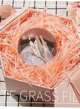 gift lined with shredded paper filling, colored packing box