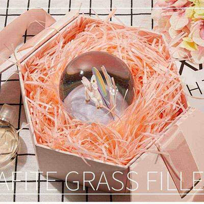 gift lined with shredded paper filling, colored packing box