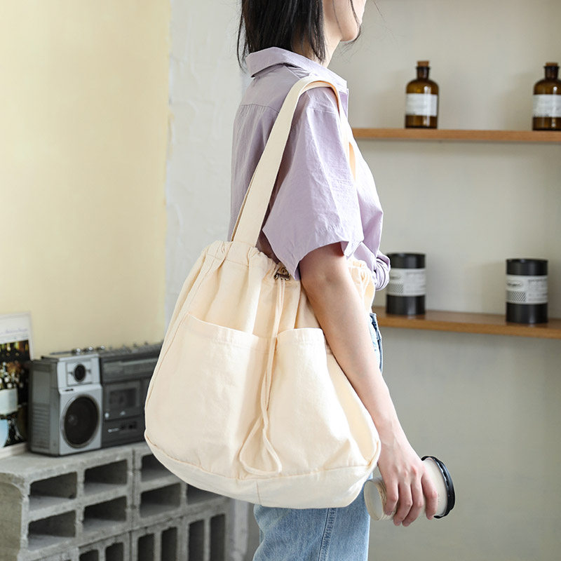 日系抽绳束口帆布包女简约百搭单肩帆布袋大容量学生手提布袋包