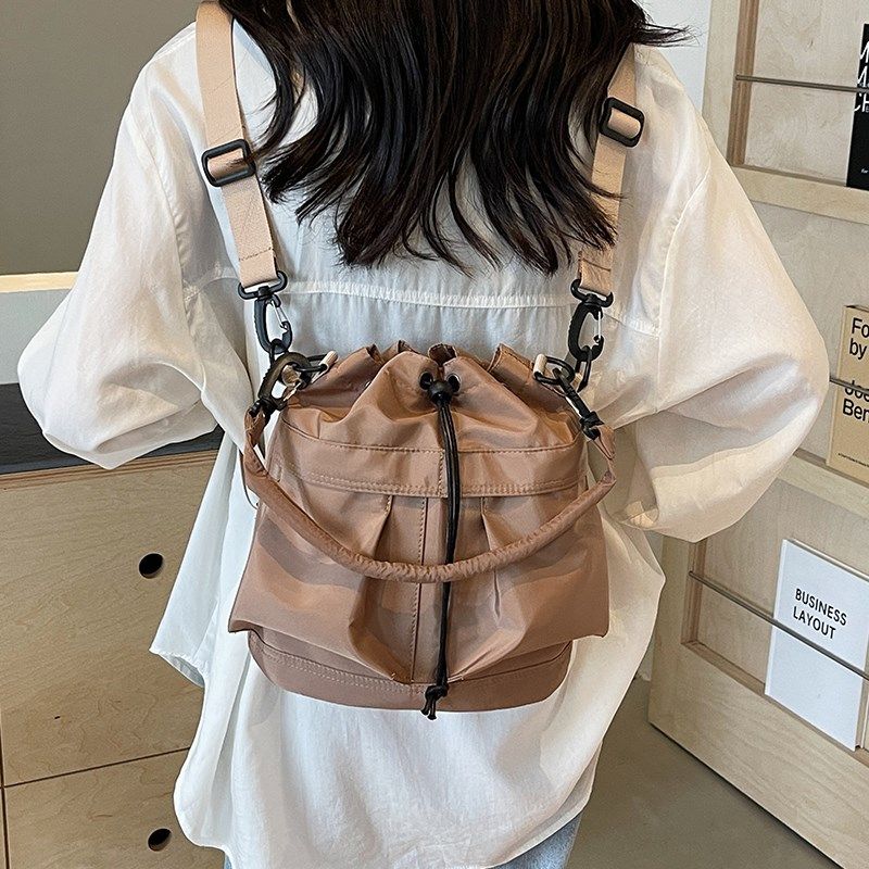 双肩斜挎两用包包女士2024新款轻便旅行抽绳背包休闲尼龙水桶布包