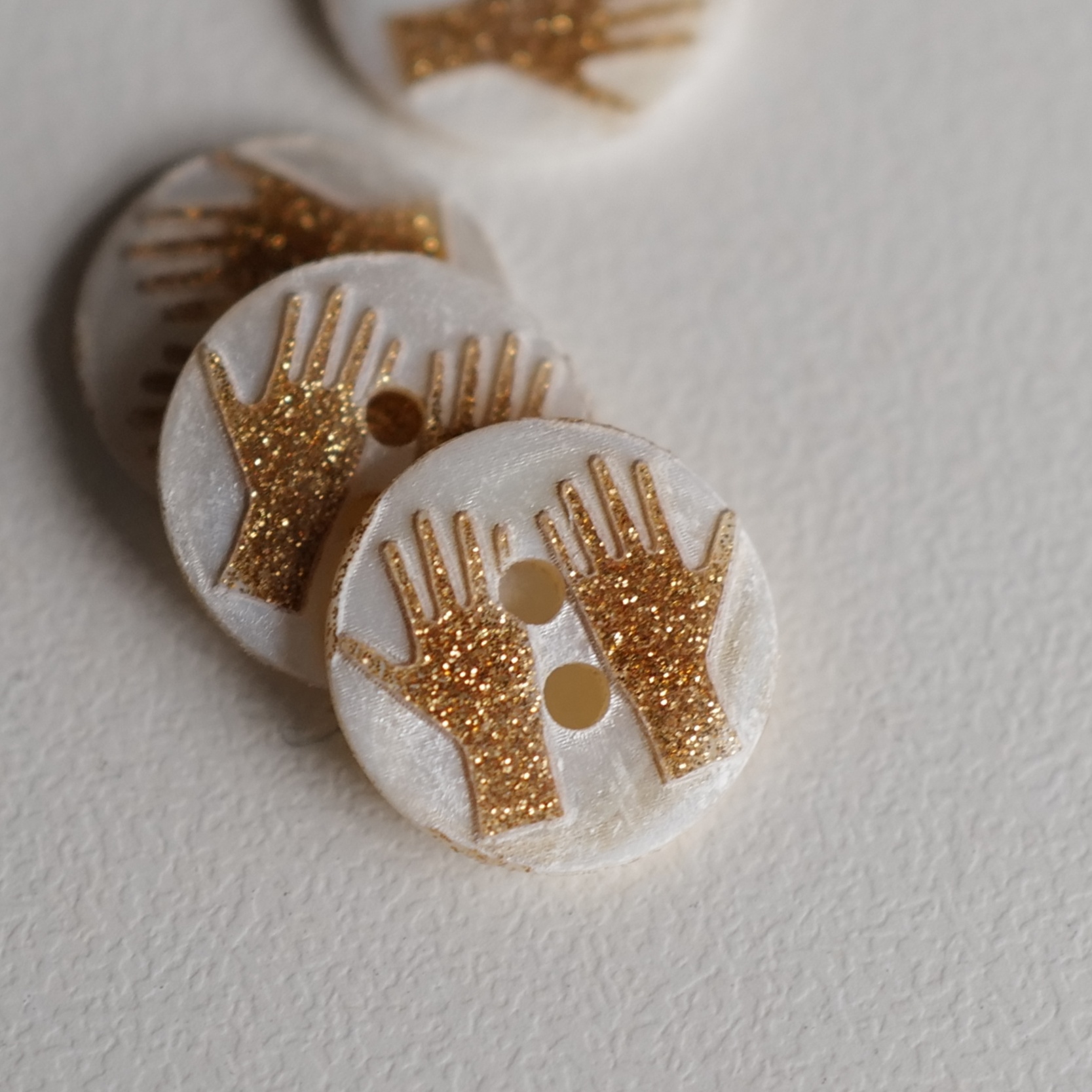 白贝壳凸出金色闪耀手形纽扣
