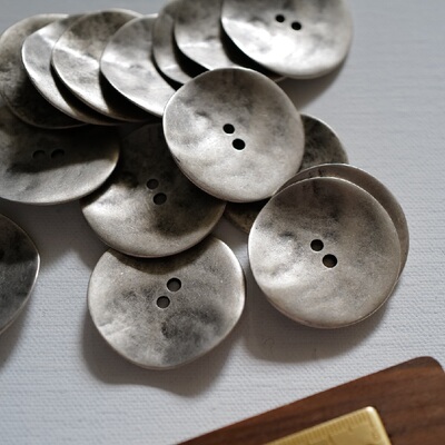 偏银色的锌金属不平整纽扣