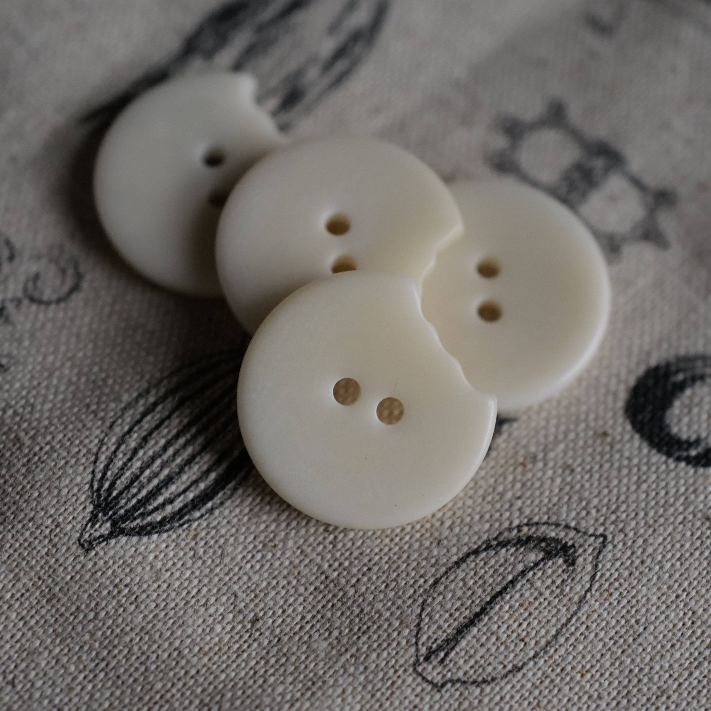 咬了一口的圆自然白未染色纽扣