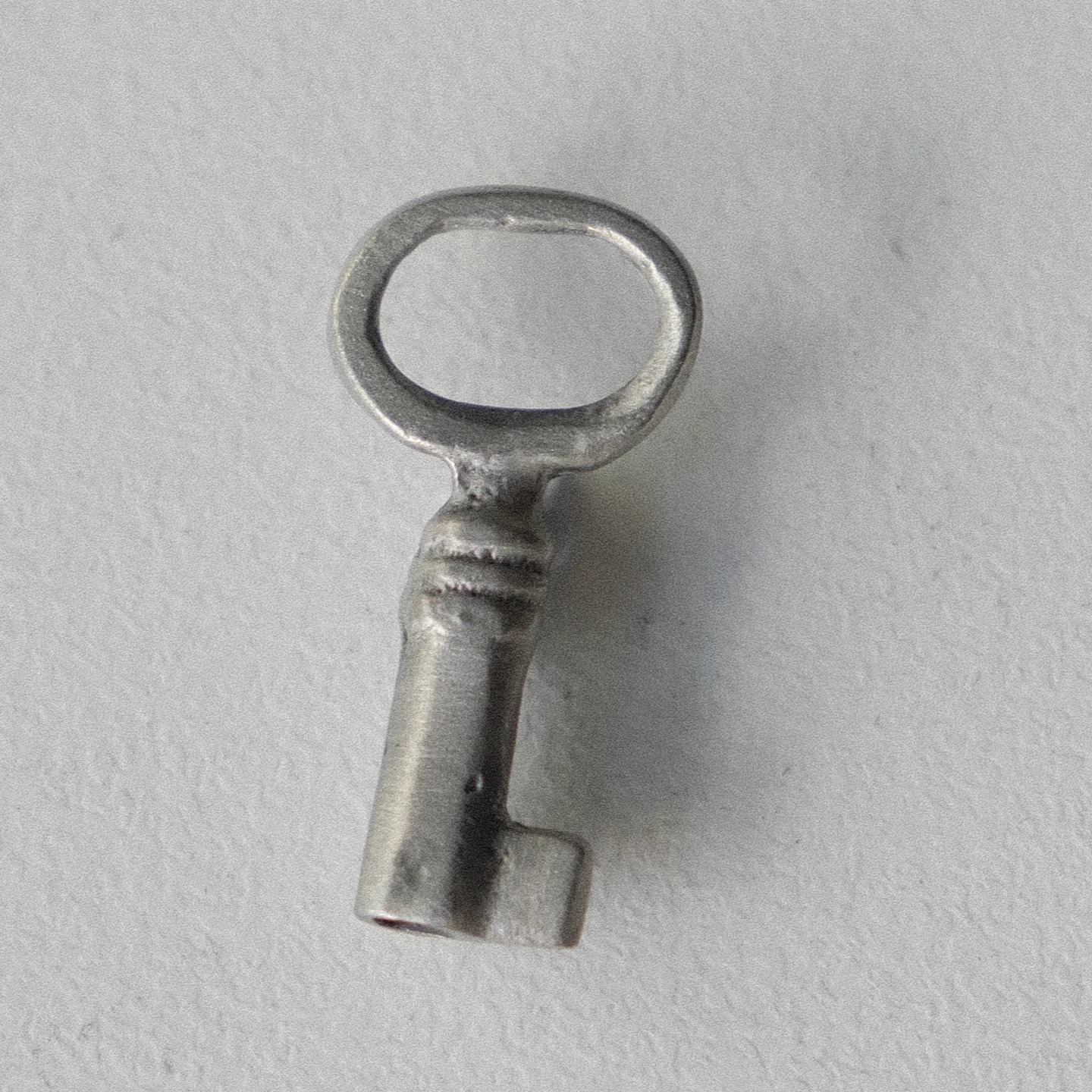 哑光冷银色椭圆孔钥匙造型纽扣