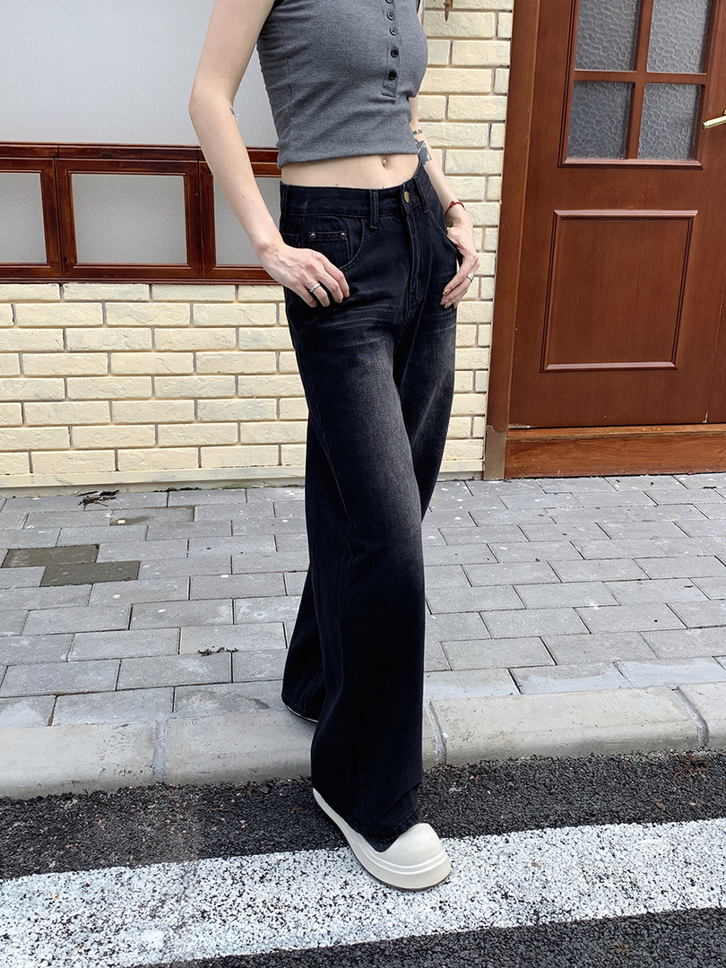 Model wearing a gray cropped tank top and black wide-leg jeans