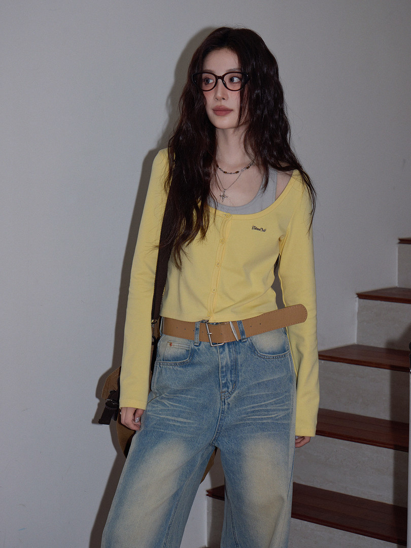 Model wearing a yellow cardigan top with jeans and a belt