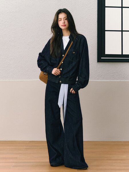 Model wearing a dark denim jacket and wide-leg jeans outfit