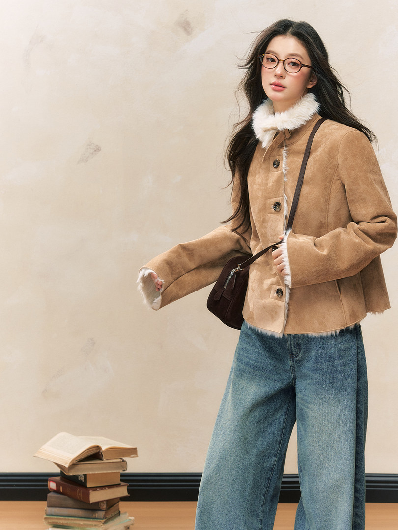 Model wearing a tan faux-shearling jacket with blue jeans