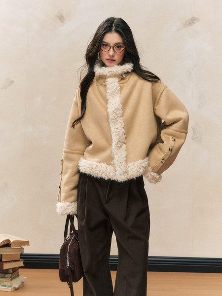 Beige shearling-trim jacket worn by a model with dark trousers