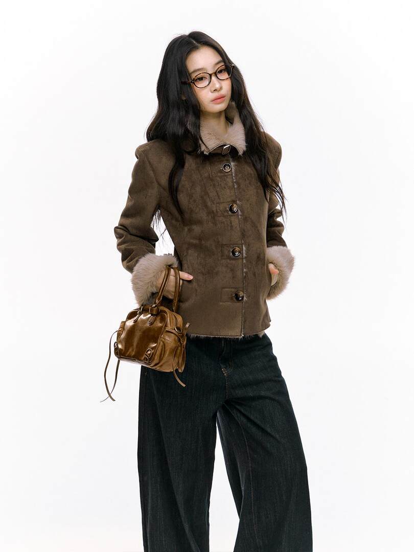 Brown fur-trimmed coat worn by a model with a small leather handbag