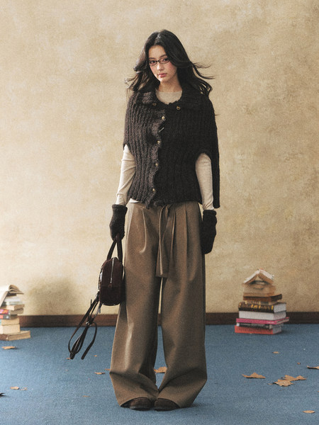 Fashion model wearing a dark knit top with wide-leg trousers and gloves