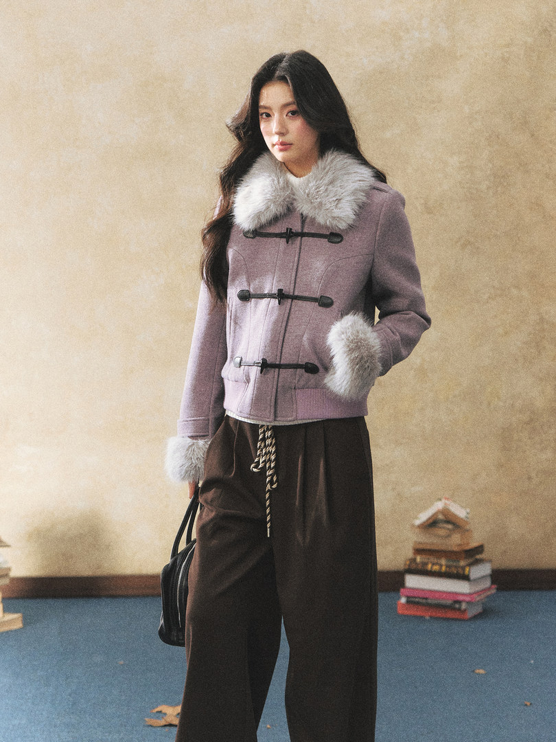 Model wearing a lavender winter coat with fur trim and toggle closures