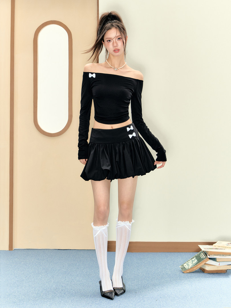 Black off-shoulder long-sleeve top with matching mini skirt worn on a model