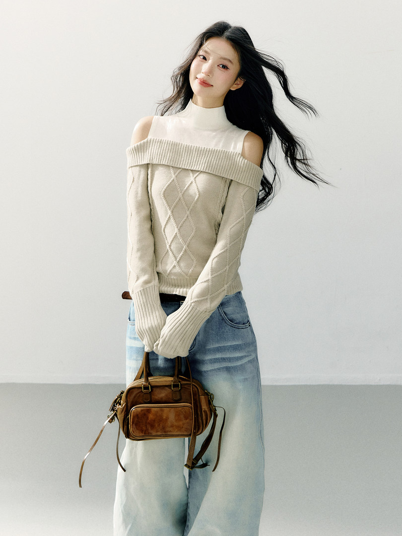 Model wearing a cream off-shoulder knit sweater with a brown handbag