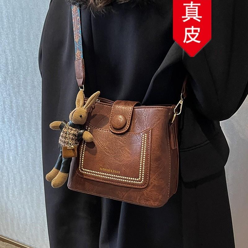 香港真皮小众覆古百搭宽肩带斜挎包包女2025新款高级感水桶包