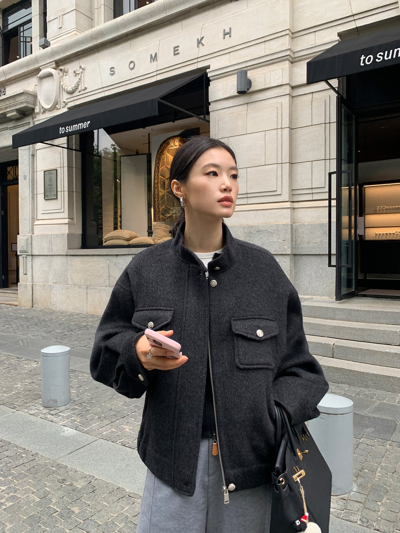 Woman wearing a dark charcoal wool jacket outdoors