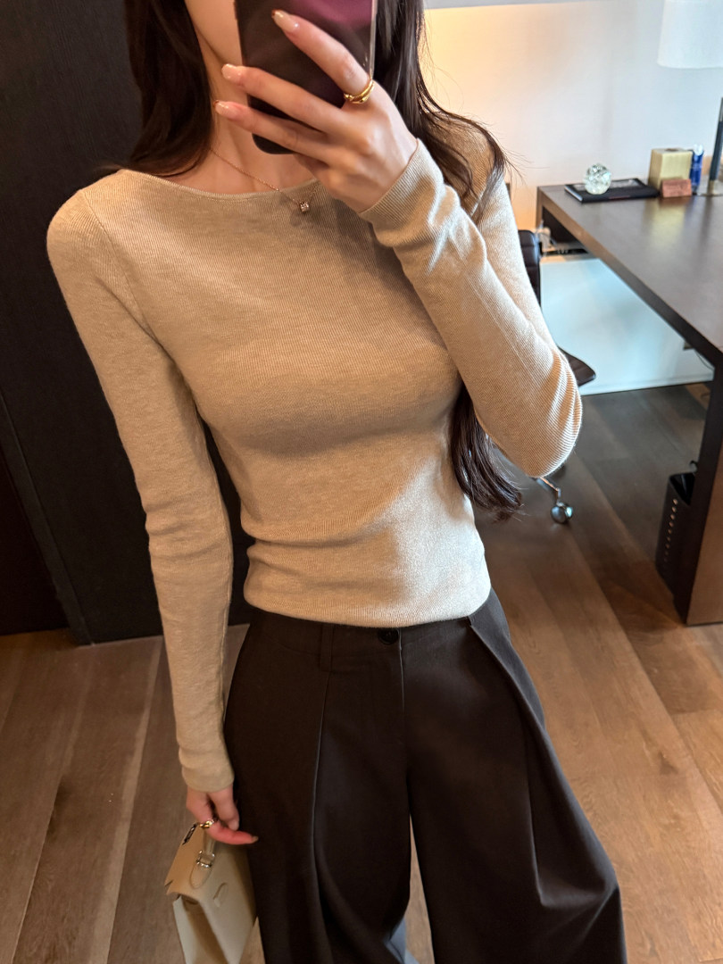 Beige fitted long-sleeve knit top worn with dark wide-leg pants
