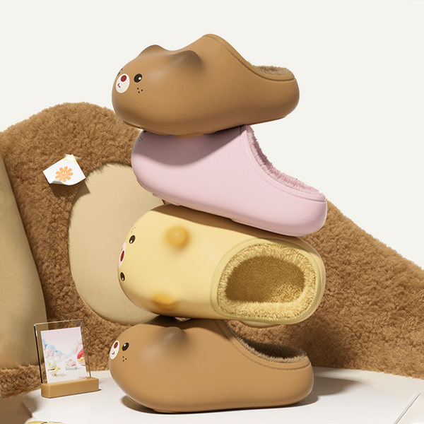 Fuzzy cartoon bear slippers stacked on display