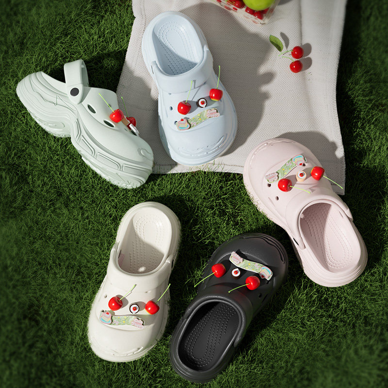 Colorful slip-on clogs with cherry decorations displayed on grass