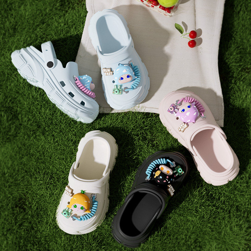 Colorful cartoon-decorated clogs displayed on grass