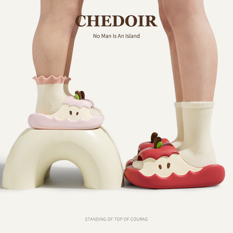 Novelty apple-shaped slippers worn on feet