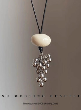Casual style sweater with chain necklace and fringed pendant