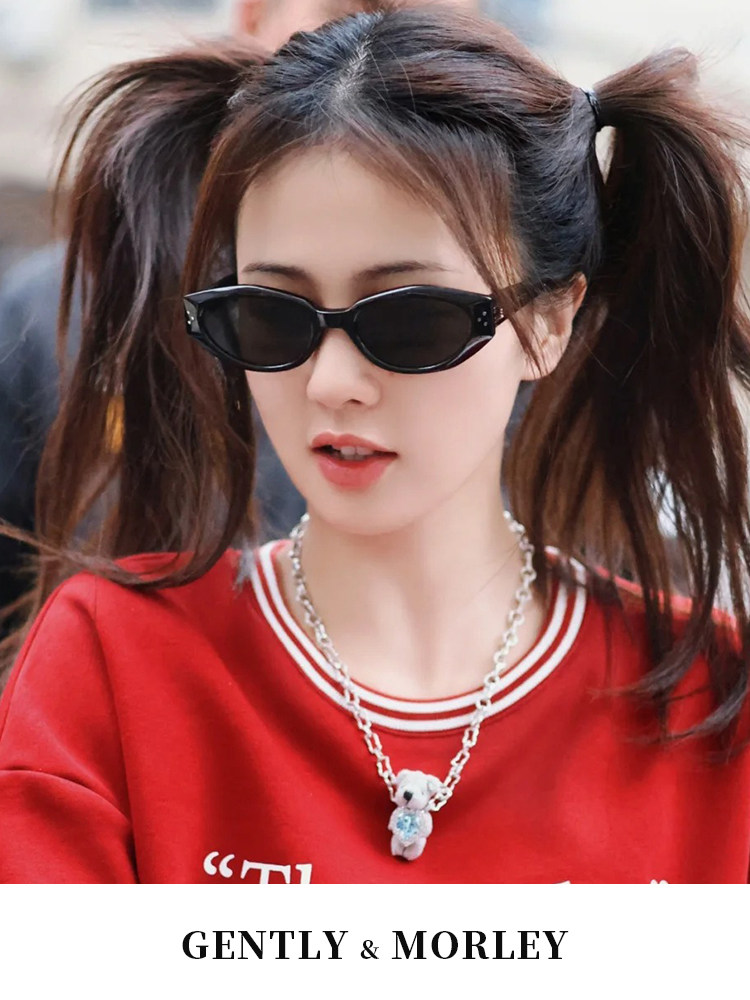 Black cat-eye sunglasses worn by a woman in a red sweatshirt