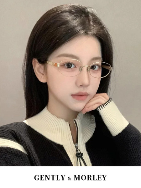 Woman wearing gold-rimmed glasses and a black-and-white zip sweater