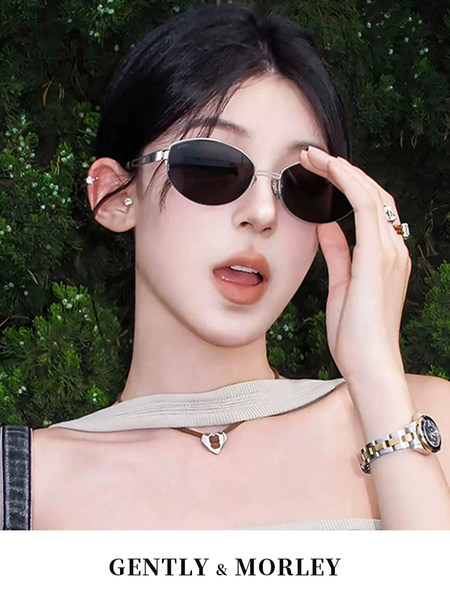 Model wearing black oval sunglasses with brand text at bottom