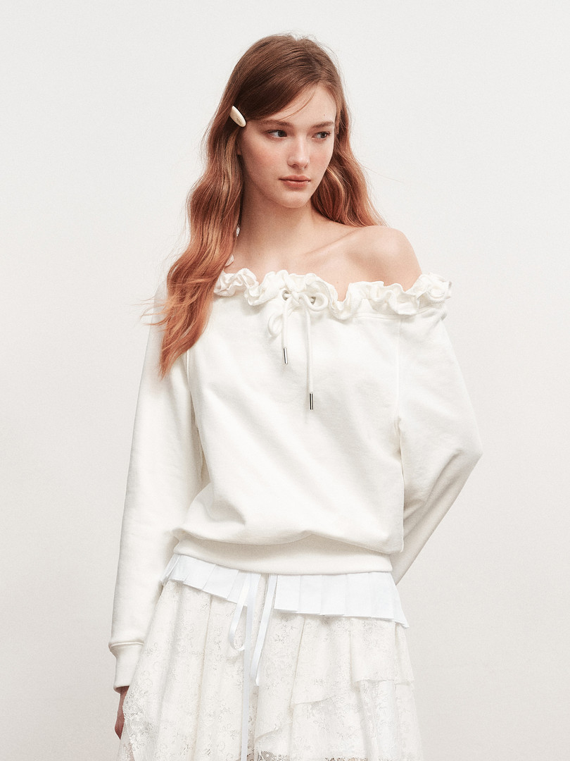 White off-shoulder ruffled sweatshirt worn by a model