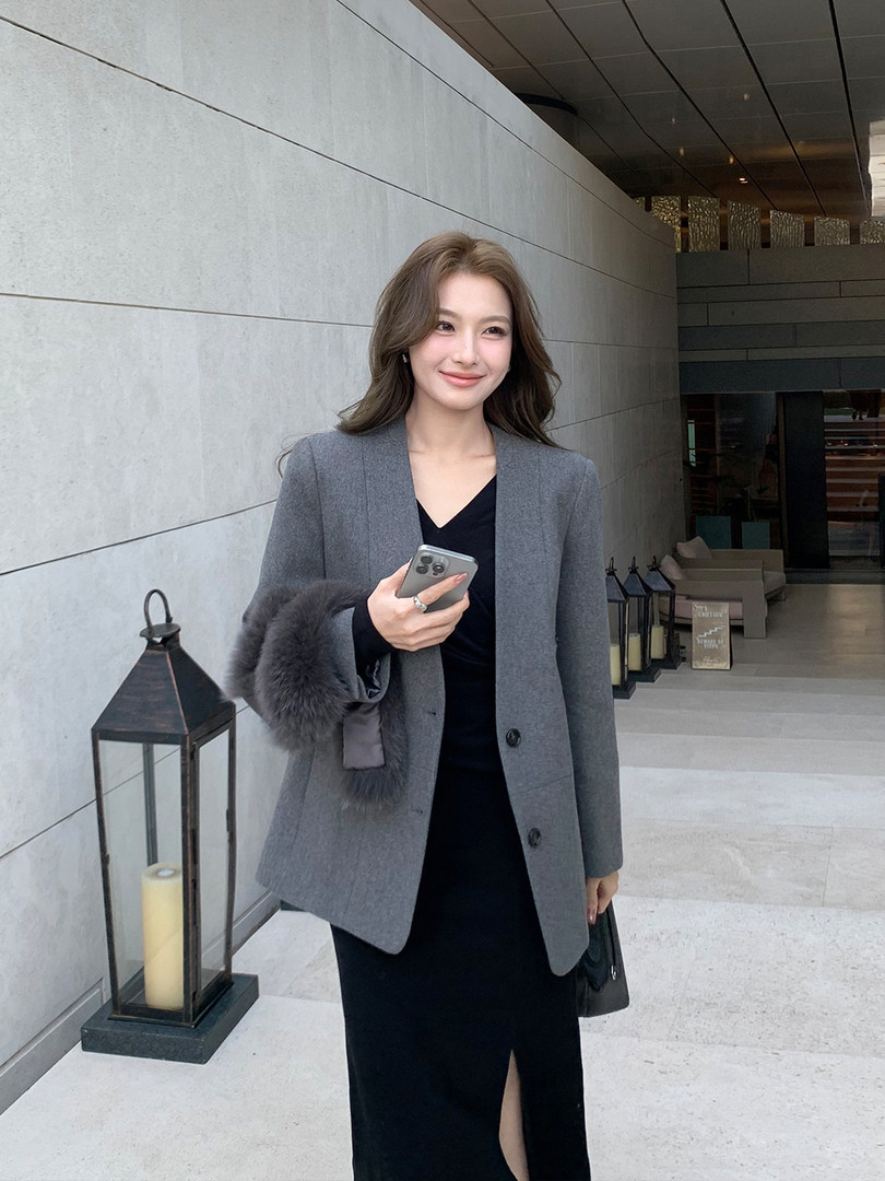 Woman wearing a gray blazer over a black dress in a chic office-style outfit