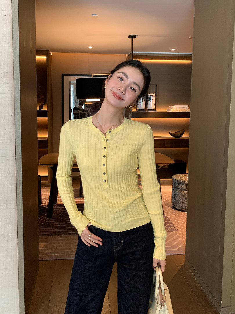 Woman wearing a pale yellow ribbed long-sleeve henley top