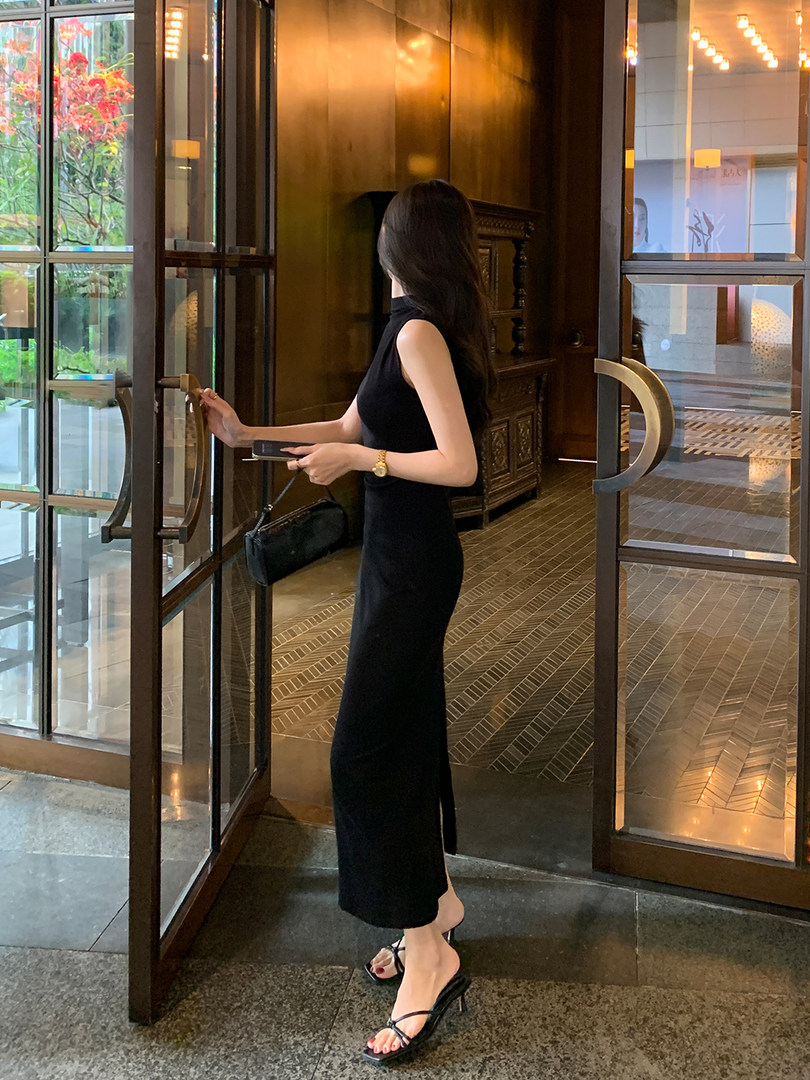Woman wearing a black sleeveless long dress with black heeled sandals