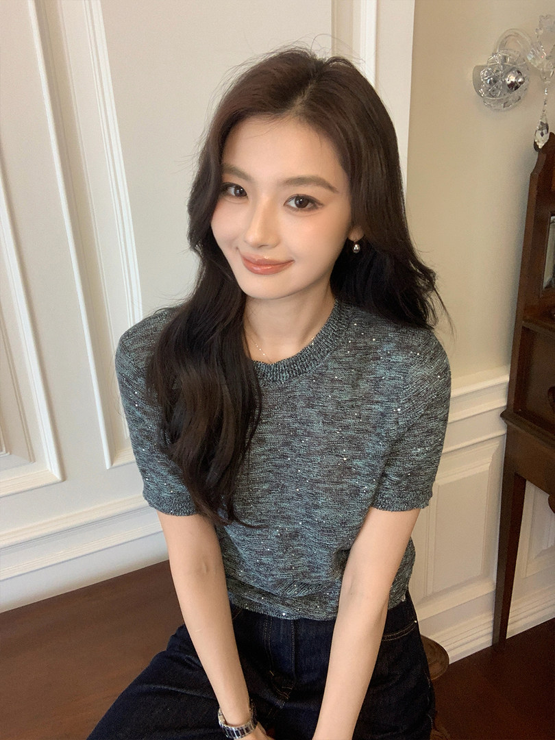 Woman wearing a short-sleeve textured knit top and dark jeans